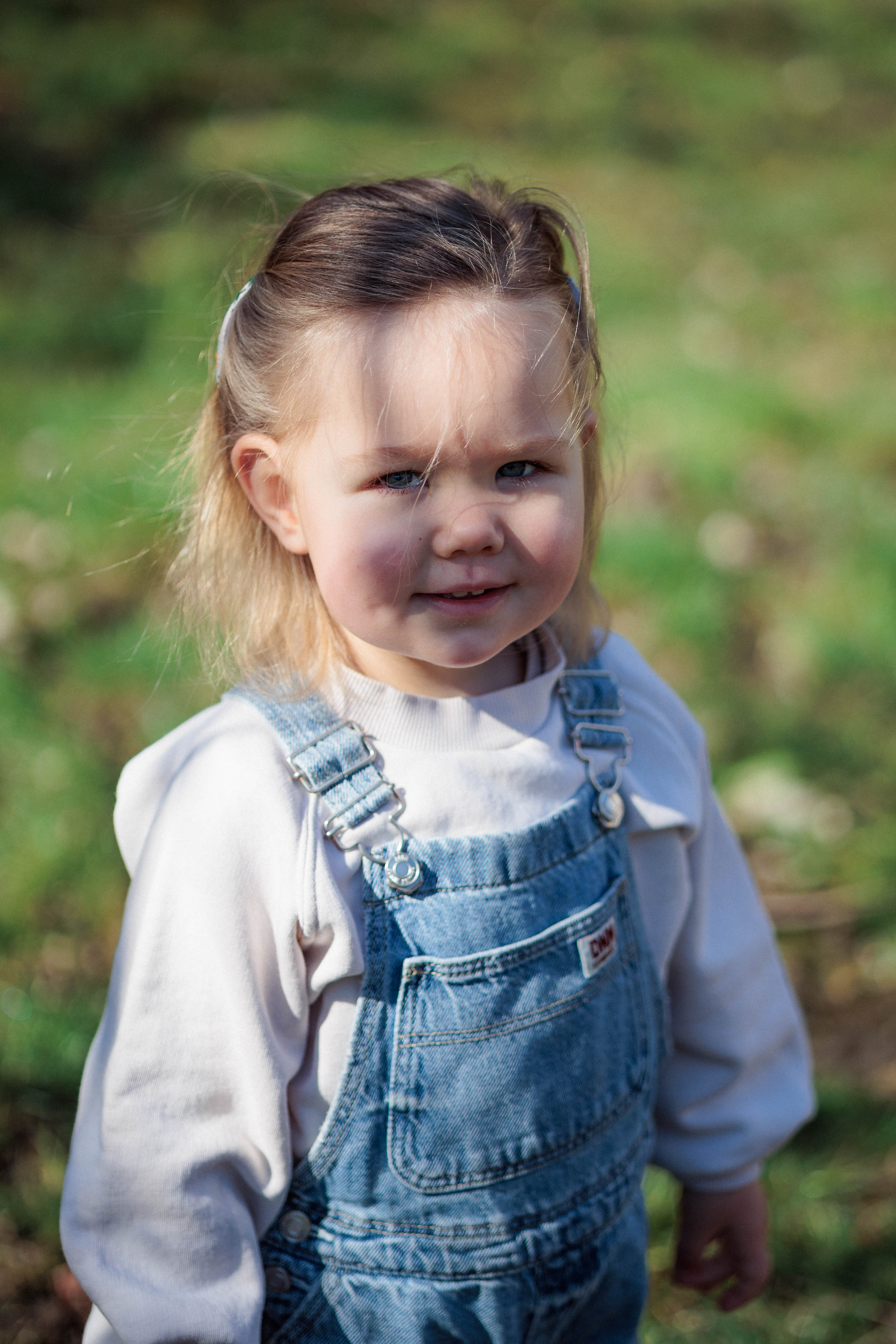 A bride and groom share a kiss surrounded by a joyful bridal party.